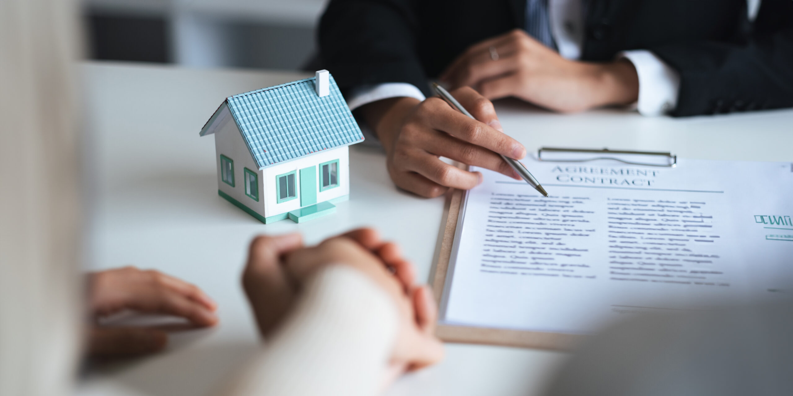 Firma de contrato inmobiliario con casa en miniatura para representar una hipoteca pagada y la cancelación de cargas en Castellón